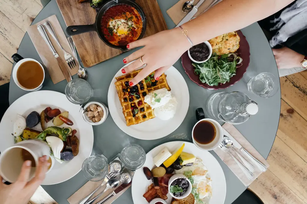 Brunch plates and coffee on a cafe dining table.