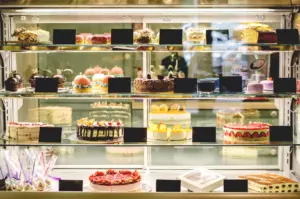 Bakery display case with assorted cakes and pastries in cafe