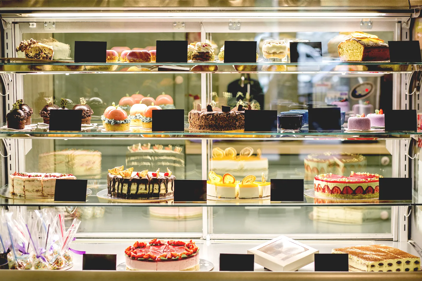 Bakery display case with assorted cakes and pastries in cafe
