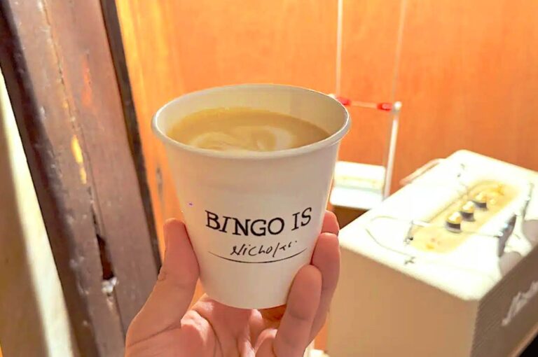 174BINGO Singapore coffee in paper cup with latte art held in hand showing minimalist takeaway coffee ritual and street side cafe experience