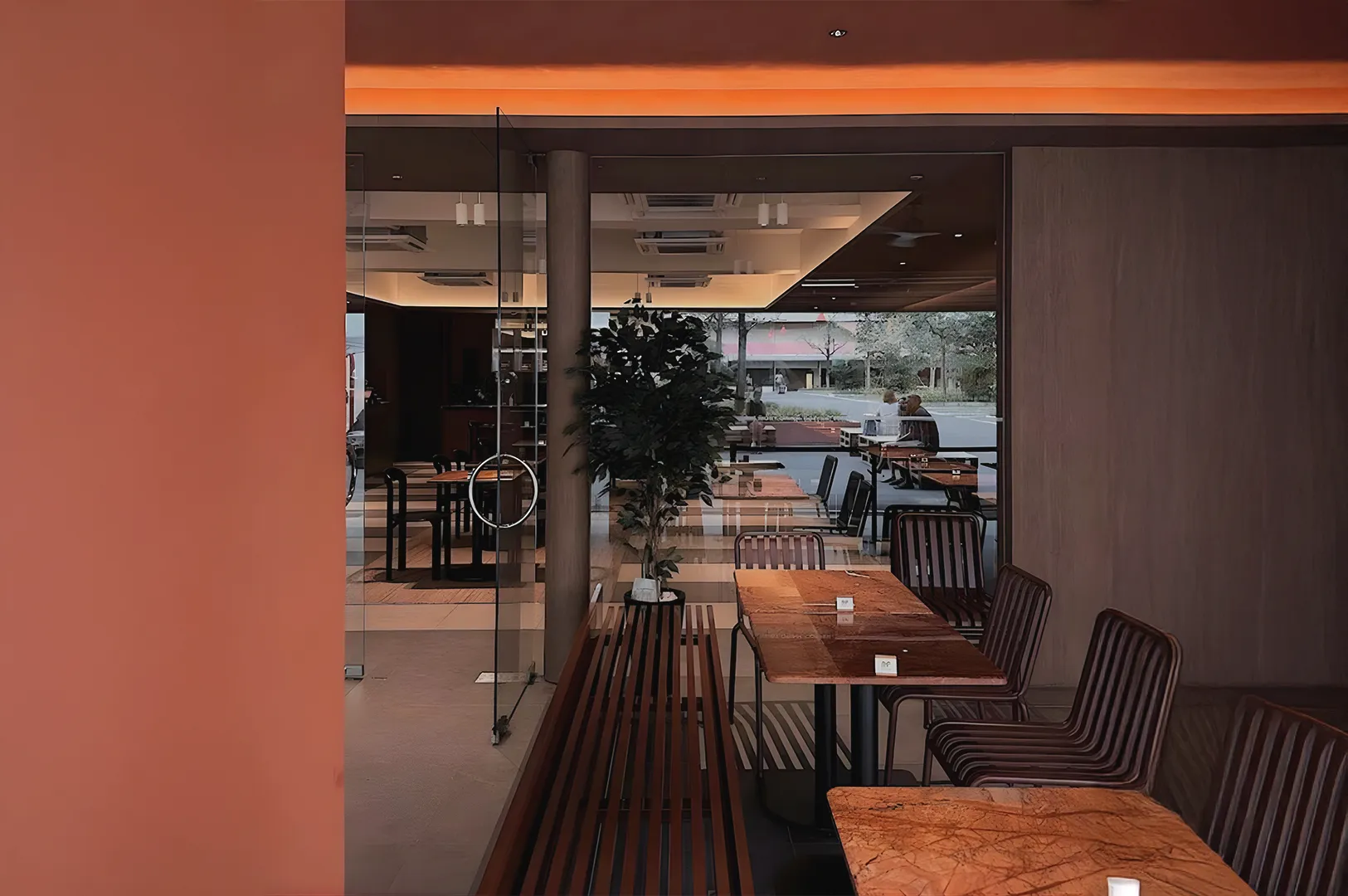Moody Singapore cafe interior with shadowed seating and empty corner tables highlighting quiet spaces away from main cafe activity