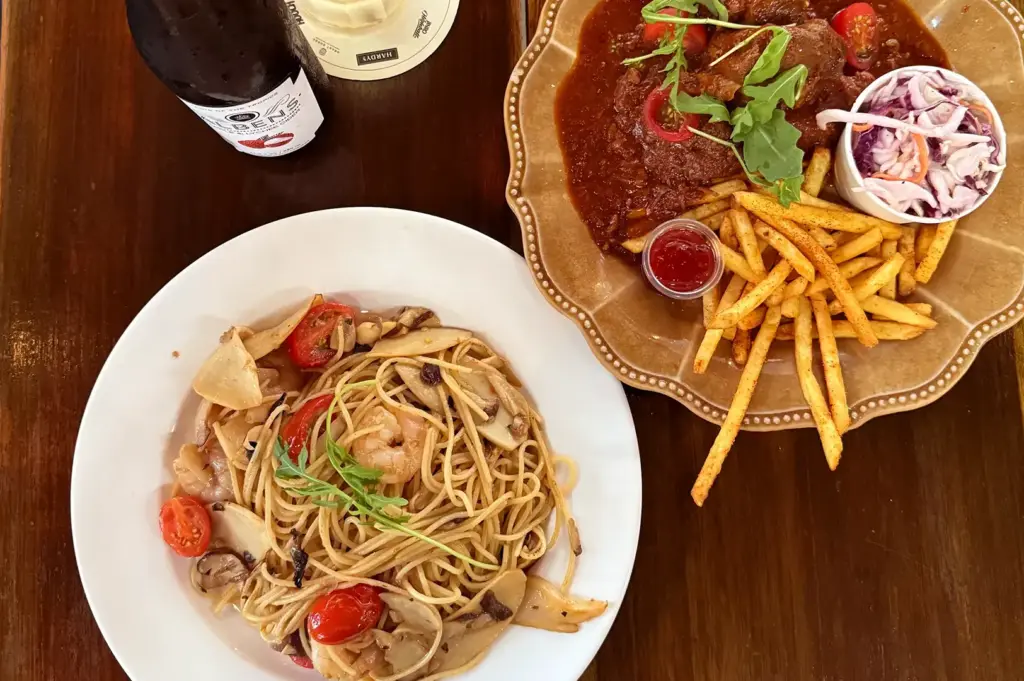 Pasta with mushrooms and tomatoes, steak with fries.