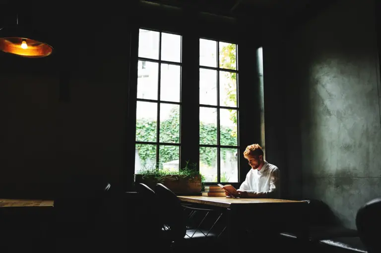 Quiet cafe corner in Singapore with a single person by the window and soft shadows capturing peaceful post-rush cafe atmosphere