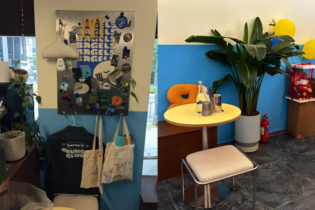 Bagel-themed wall display with tote bags, posters, and a potted plant.